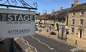 "a street corner with a sign for "" stage "" and a restaurant called "" 1 7 7 3 4 3 2 3 4 ""." at Deeping Stage