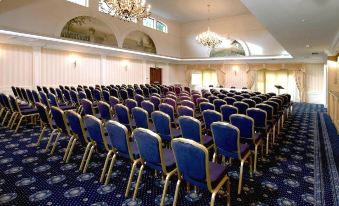 a large conference room with rows of chairs arranged in a symmetrical pattern , ready for a meeting or event at Tre-Ysgawen Hall & Spa