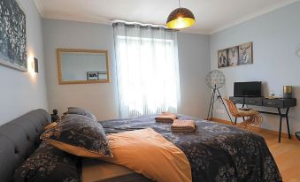 a cozy bedroom with two beds , one on the left and one on the right side of the room at Entre Terre et Mer