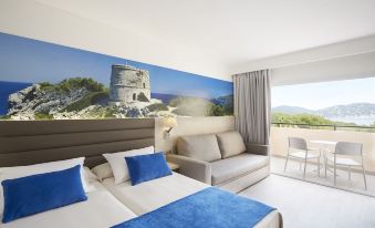 a modern hotel room with a large bed , couch , and window offering a view of the outdoors at Invisa Hotel Club Cala Blanca