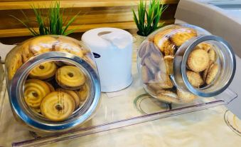 a dining table with two clear containers filled with cookies , placed next to each other at NAP in Fest