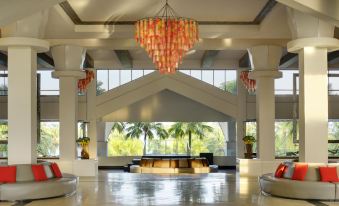 a large , well - lit hotel lobby with multiple couches and chairs , as well as a reception desk at Thistle Port Dickson Resort