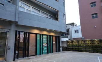 a modern building with a green door and large windows , surrounded by scaffolding and other buildings at Green Hotel