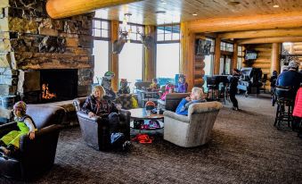 a group of people sitting in a cozy living room , enjoying each other 's company while reading books at Mont du Lac Resort