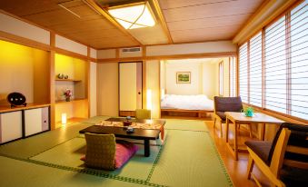 a cozy living room with a tatami mat floor , wooden furniture , and a japanese - style bedroom at Harataki