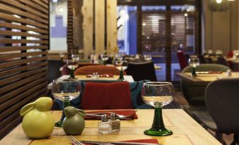 a dining room with a table set for a meal , featuring a variety of dishes and utensils at Ibis Styles Chaumont Centre Gare