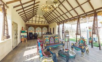 a spacious living room with wooden beams and a high ceiling , featuring colorful furniture and a chandelier at Serena Beach Resort