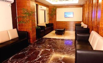 a modern hotel lobby with a marble floor , black couches , and a large screen on the wall at Imperial Heights