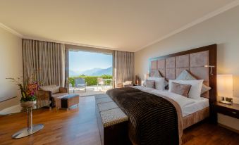 a luxurious hotel room with a king - sized bed , wooden floors , and a view of the mountains at Le Mirador Resort and Spa