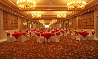 a large banquet hall with multiple tables and chairs arranged for a formal event , possibly a wedding reception at Radisson Blu New Delhi Dwarka