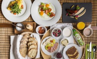 a table is set with various dishes , including bread and a salad , as well as plates of food at Villa Rosa