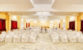 a large , empty banquet hall with rows of white chairs and tables set up for an event at Hotel Empire