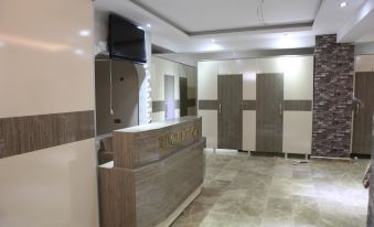 a modern , empty restroom with beige walls and marble floors , featuring a television mounted on the wall at Mostar Hotel