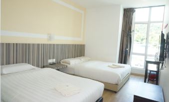 a hotel room with two beds , one on the left and one on the right side of the room at Sun Inns Hotel Ayer Keroh