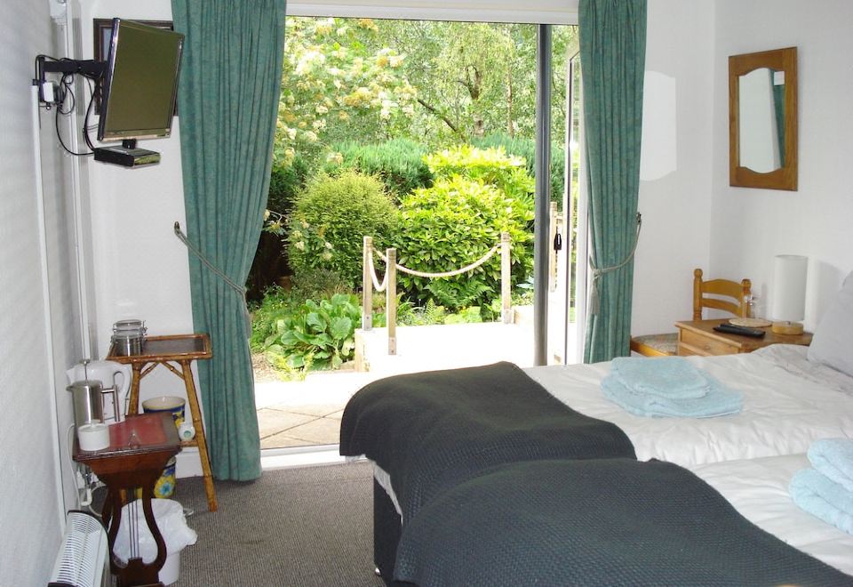 a bedroom with a bed and curtains , and a sliding glass door leading to an outdoor area at Wildwinds