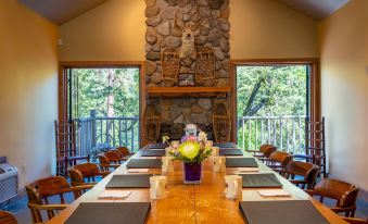 a long wooden dining table set up for a formal meal , with multiple chairs arranged around it at Weasku Inn