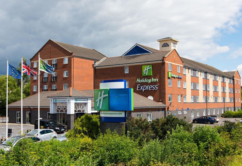 an exterior view of a holiday inn express hotel with a parking lot in the foreground at Holiday Inn Express Newcastle Gateshead