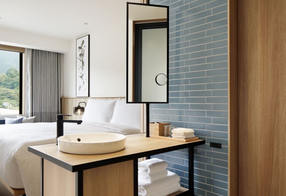 a modern hotel room with a blue and white tiled wall , wooden furniture , and a white sink at Fairfield by Marriott Gifu Seiryu Satoyama Park