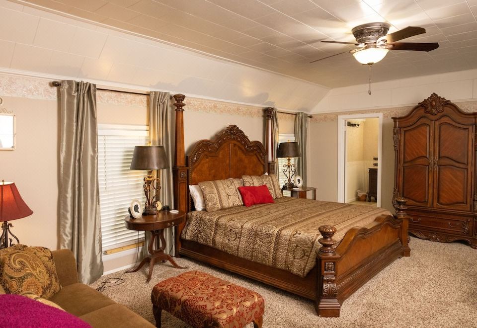 a large bedroom with a king - sized bed , multiple pieces of furniture , and a ceiling fan at Sassafras Inn