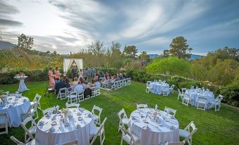 a wedding reception is taking place on a grassy lawn , with tables and chairs set up for guests at Civana Wellness Resort & Spa