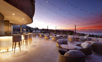a rooftop bar with several chairs and tables , creating a comfortable and inviting atmosphere for patrons at Hard Rock Hotel Tenerife