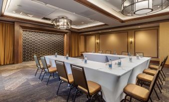 a conference room with a long table surrounded by chairs , and several bottles of water placed on the table at Cambria Hotel - Arundel Mills BWI Airport