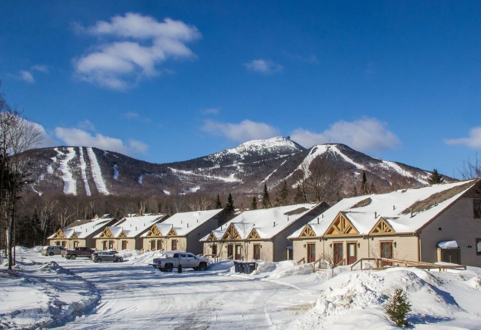 a snow - covered ski resort with a mountain in the background and multiple buildings in the foreground at Jay Peak Resort