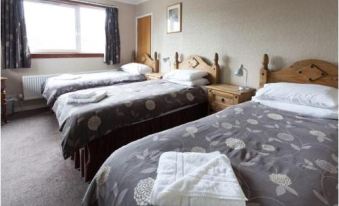 a hotel room with two beds , each made with white sheets and towels , under wooden nightstands at Queens Hotel