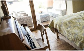 a wooden piano is sitting in a room next to a bed with a patterned blanket at The View