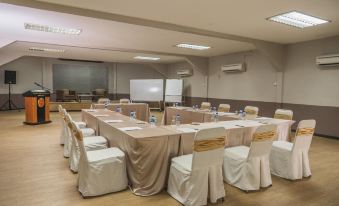a conference room set up for a meeting , with chairs arranged in a semicircle around a long table at Shah's Beach Resort