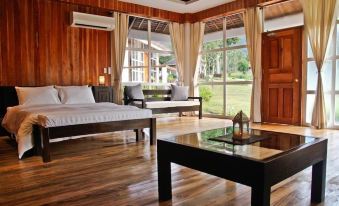 a spacious bedroom with hardwood floors , a large bed , and a sliding glass door that leads to a patio area at Recidencia Del Hamor