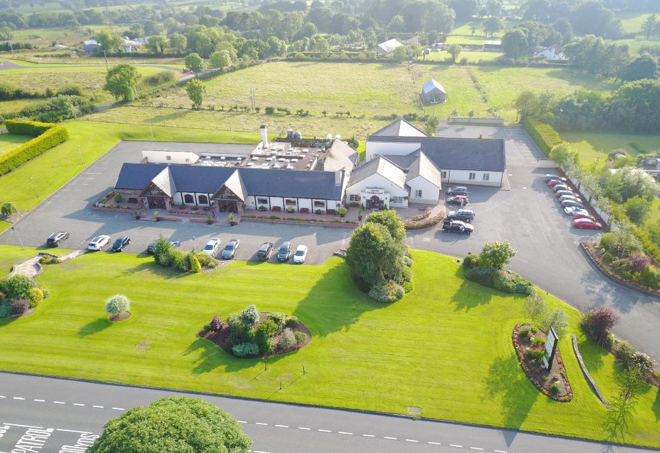 an aerial view of a large building complex with multiple buildings , cars parked in the lot , and a parking lot at Ballymac Hotel