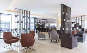 a modern hotel lobby with various seating options , including couches and chairs , creating a comfortable atmosphere for guests at Hotel Bristol 4 Sup