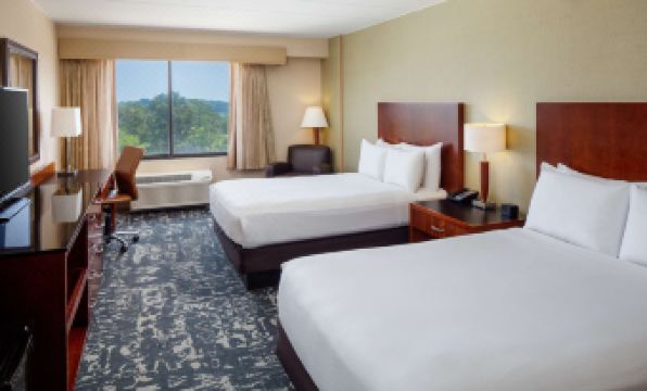 a hotel room with two beds , nightstands , and lamps , as well as a view of the mountains outside the window at DoubleTree by Hilton Hotel Boston North Shore