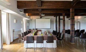 a conference room set up for a meeting , with tables and chairs arranged in a square formation at Parador de Argomaniz