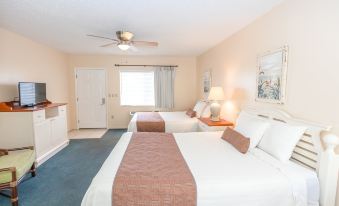 a hotel room with two beds , one on the left and one on the right side of the room at Belleair Beach Resort Motel