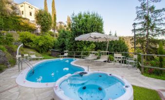 a backyard with a swimming pool surrounded by lounge chairs and umbrellas , providing a relaxing atmosphere at Villa Alta - Residenza d'Epoca Con Piscina