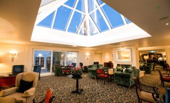 a large room with a skylight and several chairs arranged around it , creating a cozy atmosphere at The Keadeen Hotel