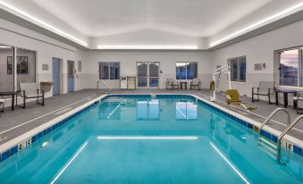 an indoor swimming pool with a blue and white interior , surrounded by white walls and windows at Staybridge Suites Pittsburgh Airport