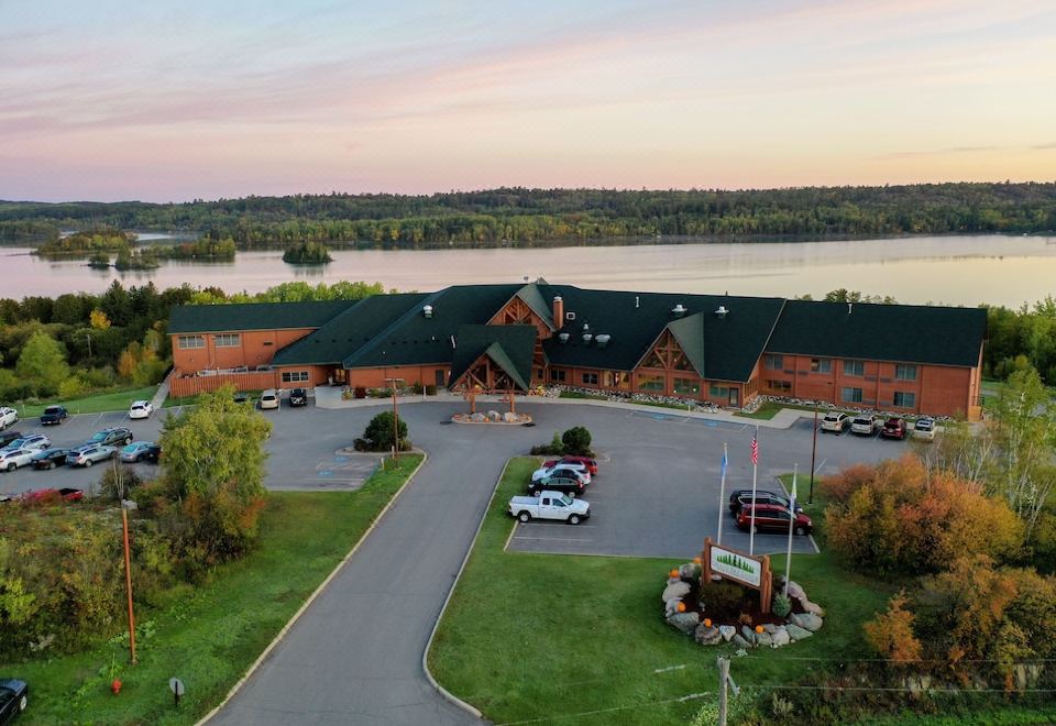 aerial view of a large building with a parking lot and cars in front of it at Grand Ely Lodge