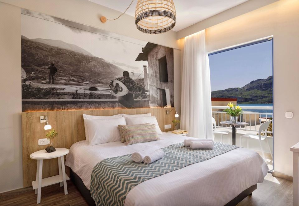 a cozy bedroom with a large bed , a television , and a window overlooking a beautiful view at Sofia Hotel
