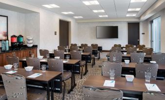 a conference room with rows of chairs arranged in a semicircle , and a television mounted on the wall at Homewood Suites by Hilton Aliso Viejo Laguna Beach