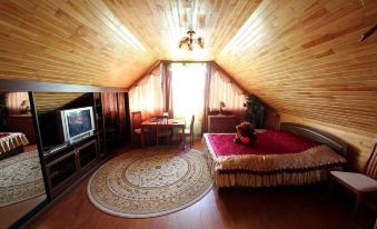 a cozy bedroom with a wooden ceiling , a bed , a tv , and a rug on the floor at Allur