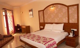 a large bed with a wooden headboard and white linens is in a room with pink curtains at Hotel Grand Riviera