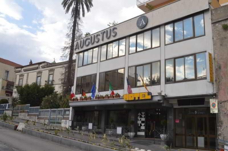 "a large hotel building with a sign that reads "" augustus "" prominently displayed on the front of the building" at Augustus
