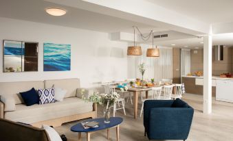 a modern living room with a couch , chairs , and dining table set up in the kitchen area at Pierre & Vacances Blanes Playa