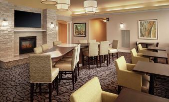 a well - lit restaurant with various dining tables and chairs , creating a comfortable atmosphere for guests at Homewood Suites by Hilton Wallingford-Meriden