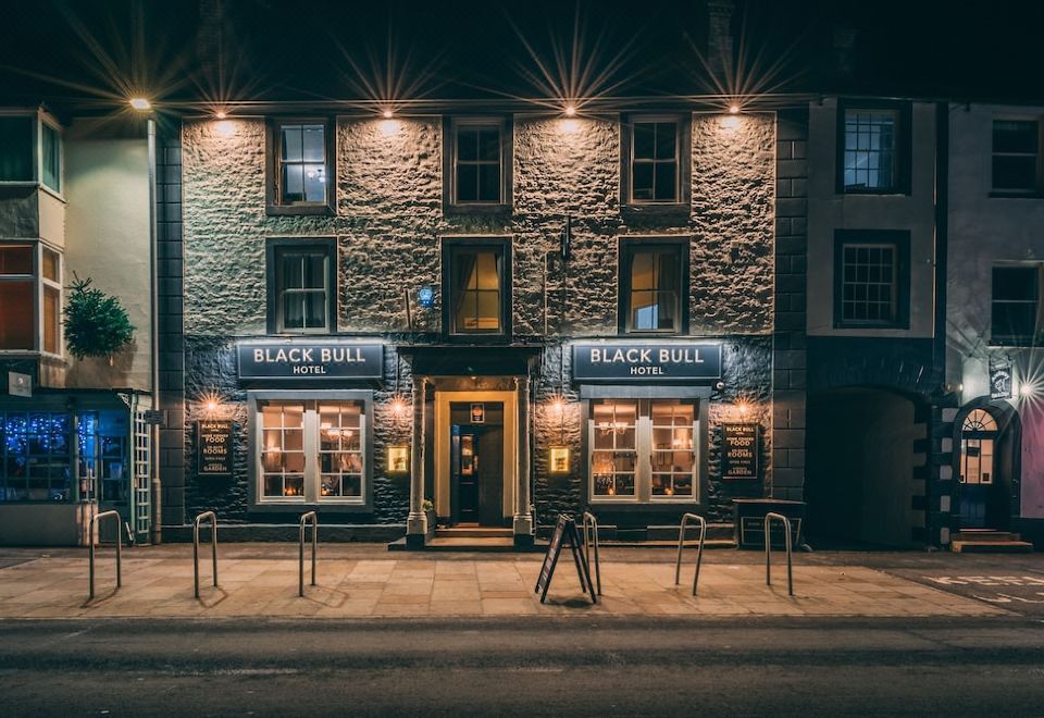 "a nighttime scene of a brick building with the name "" black bull "" on it , illuminated by street lights" at Black Bull Hotel