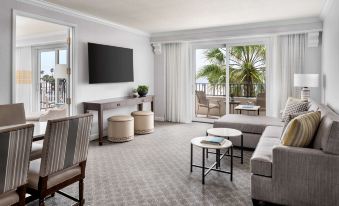 a living room with a couch , chairs , and a tv . also a dining table in the room at Hyatt Regency Huntington Beach Resort and Spa