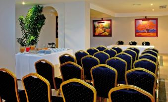 a conference room with rows of chairs arranged in a semicircle around a table , ready for a meeting at Bahia Principe Grand Cayacoa